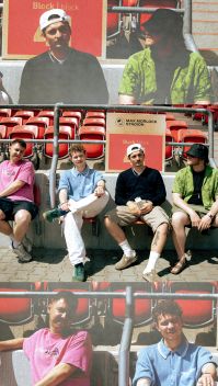 Die Band sitzt auf der Spielerbank in einem Fußballstadion | Quelle: Rufus Engelhard